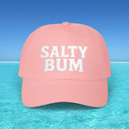 Pink cap with 'Salty Bum' text on a beach background