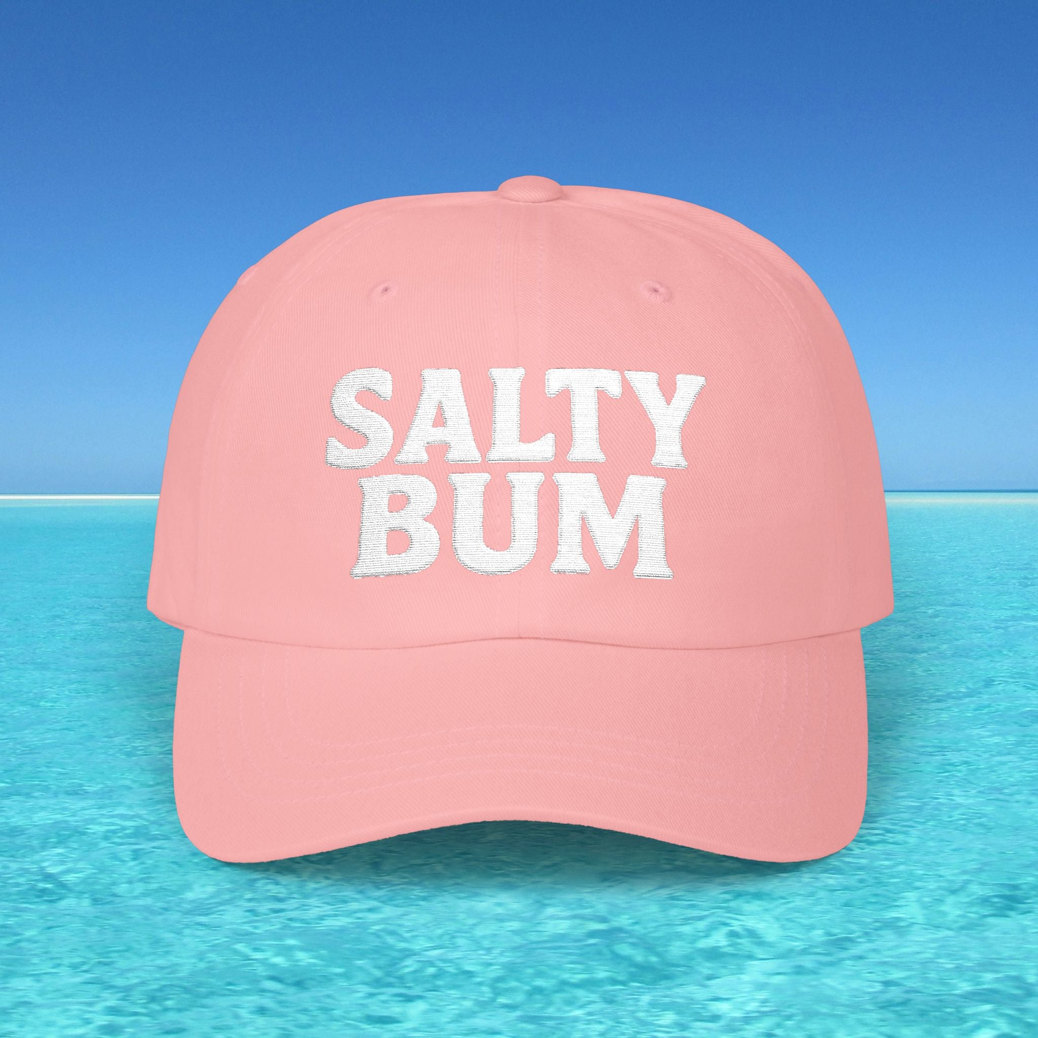Pink cap with 'Salty Bum' text on a beach background