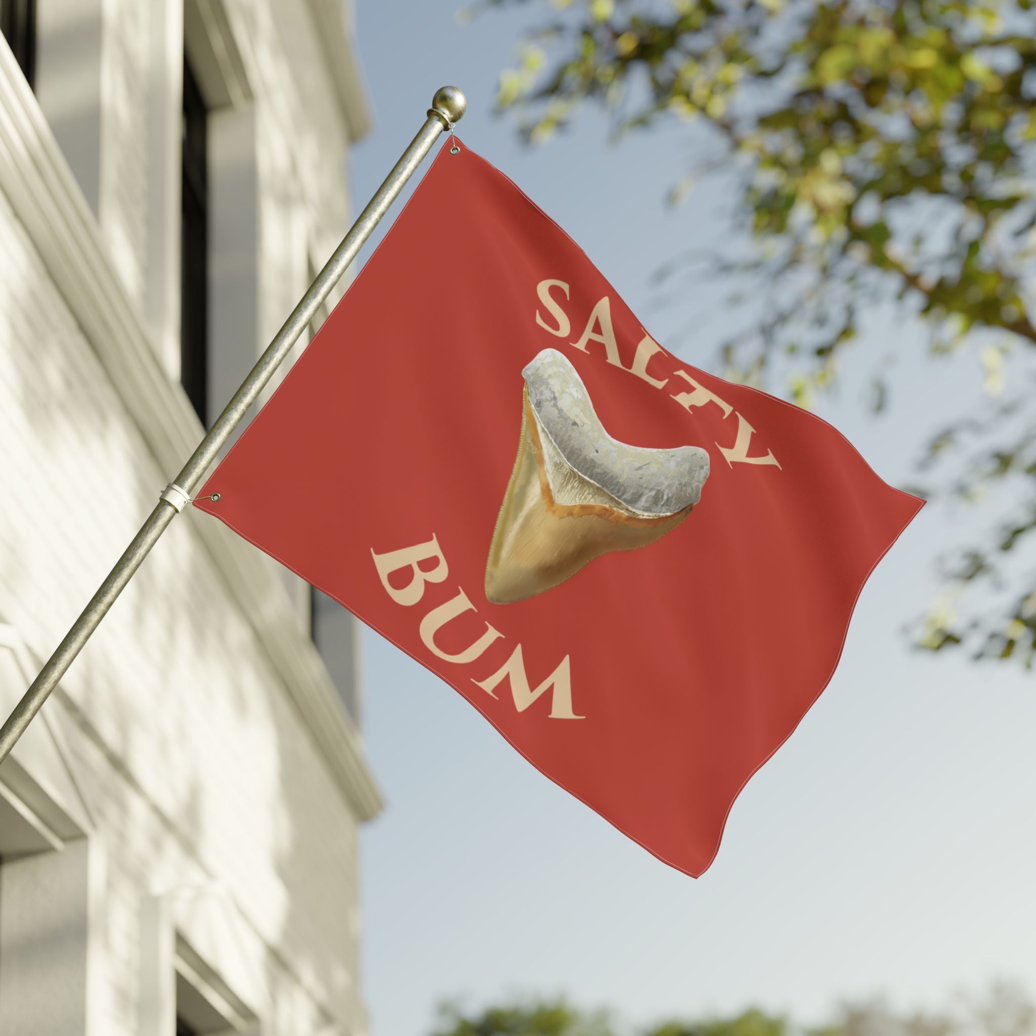 Red flag with a fortune cookie graphic and 'Salty Bum' text, waving in front of a building.