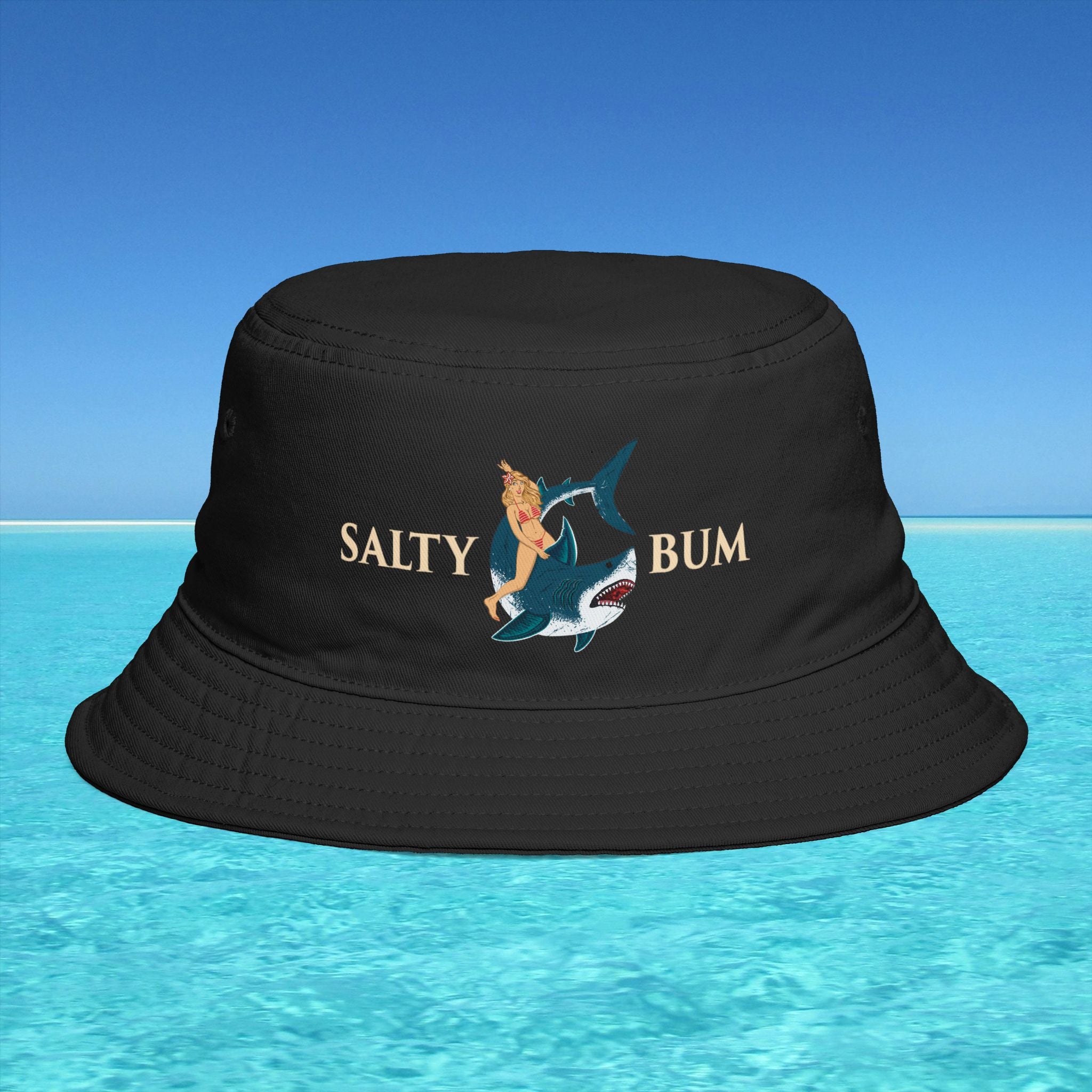 Black bucket hat with 'Salty Bum' design on a blue water background