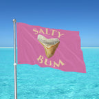 Flag with 'Salty Bum' text and a shark tooth graphic against a blue ocean and sky background