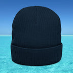 Black knit beanie on a blue and turquoise gradient background