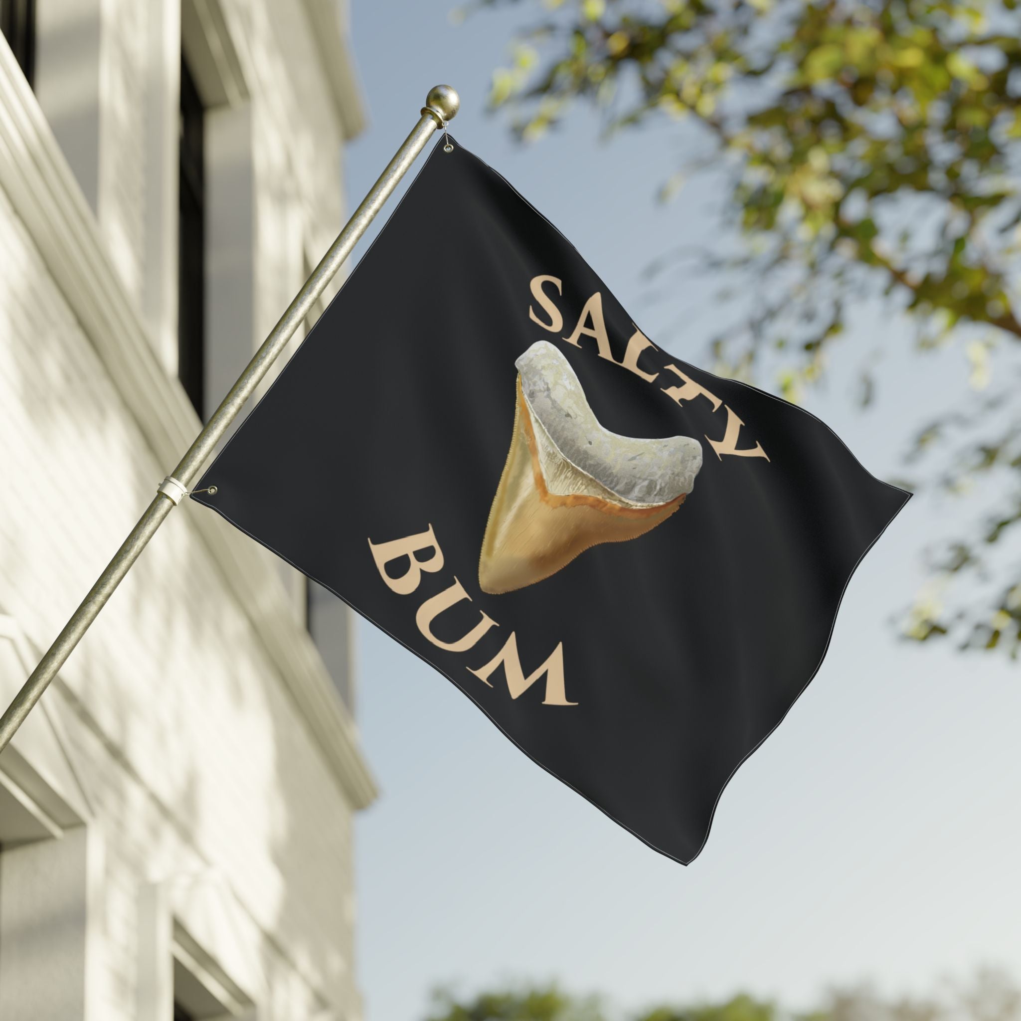 Flag with a shark tooth graphic and 'Salty Bum' text on a building exterior.