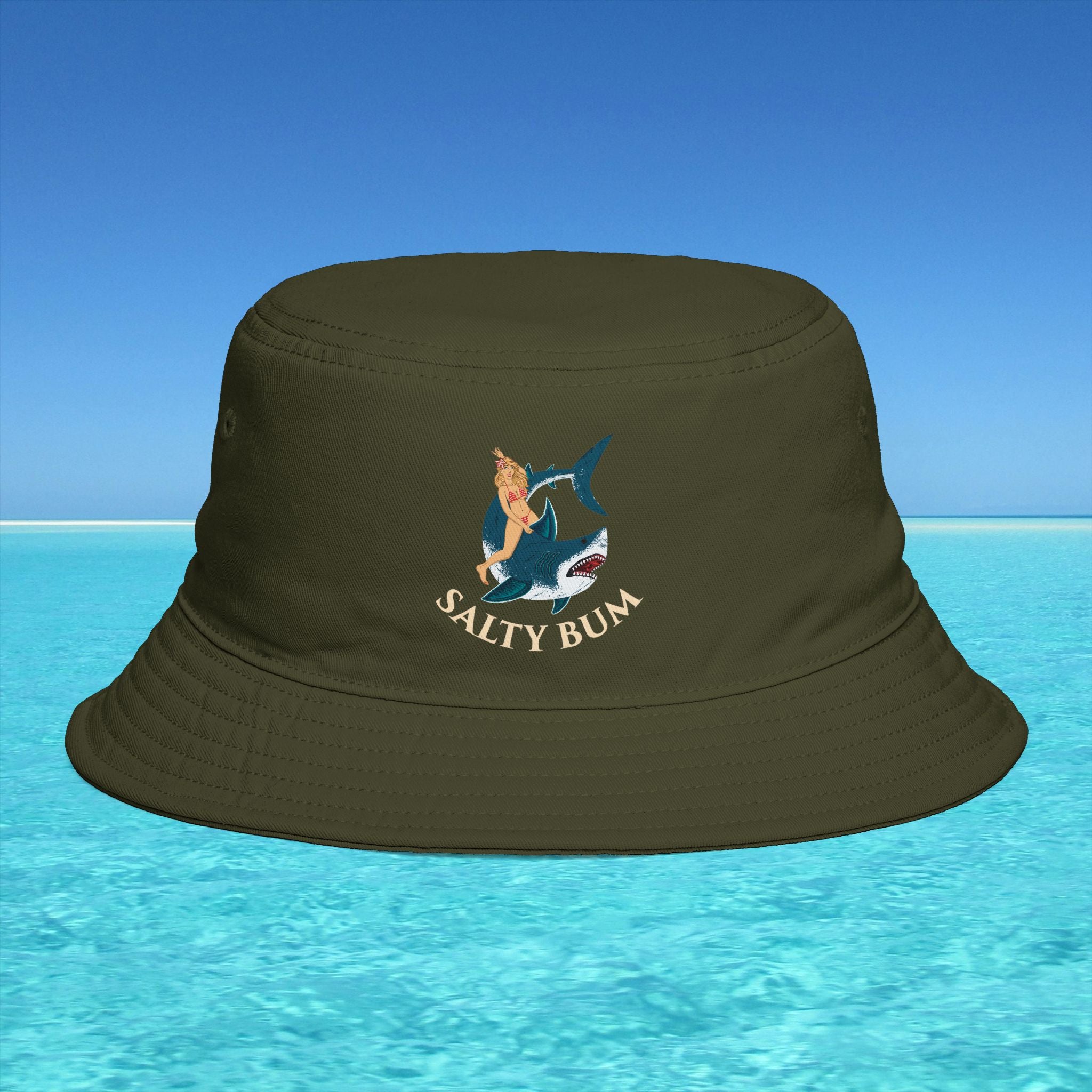 Brown bucket hat with 'Salty Bum' logo on a blue water and sky background
