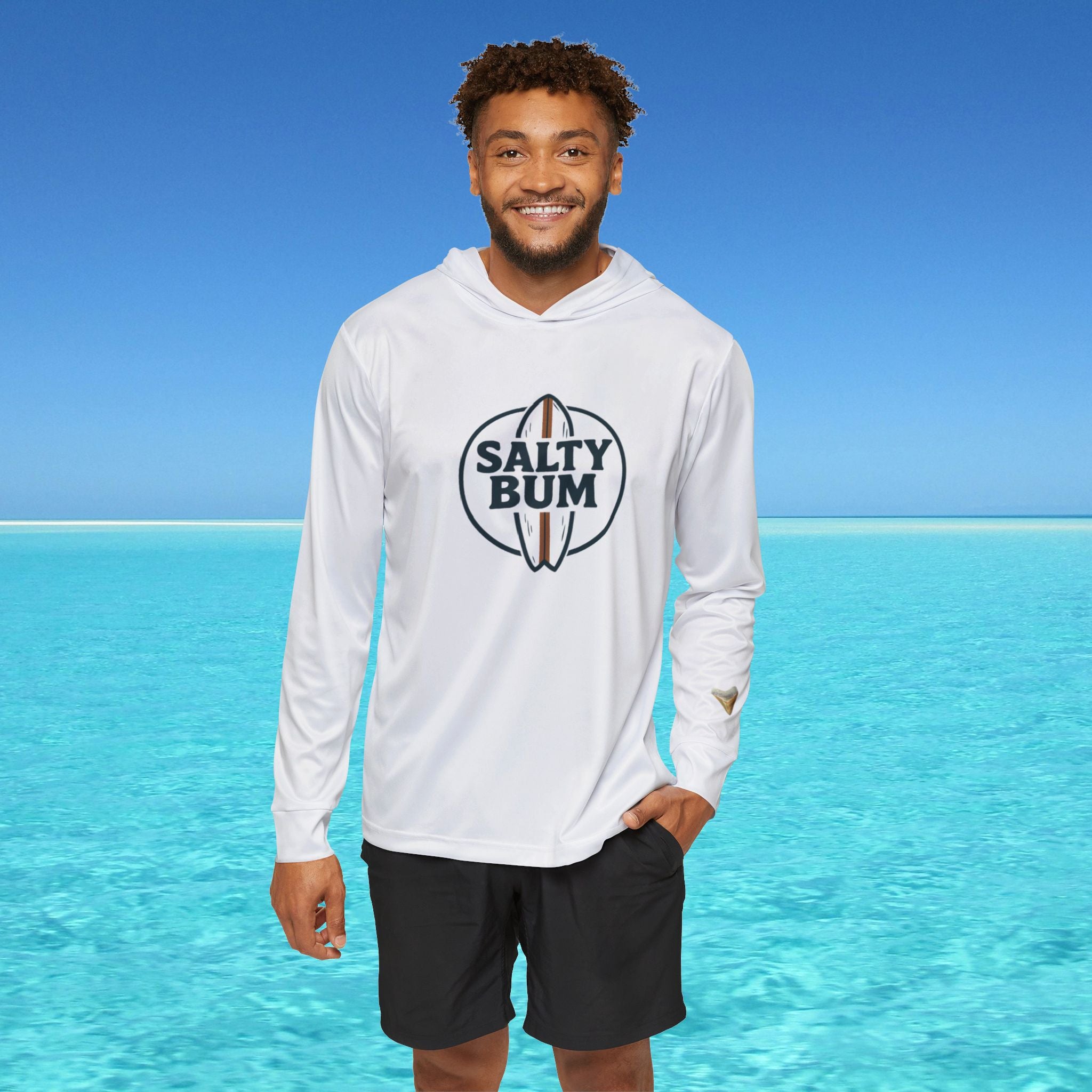 Person wearing a white hoodie with 'Salty Bum' logo against a clear blue sky and ocean.