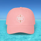 Pink cap with 'Salty Bum' logo on a blue water and sky background