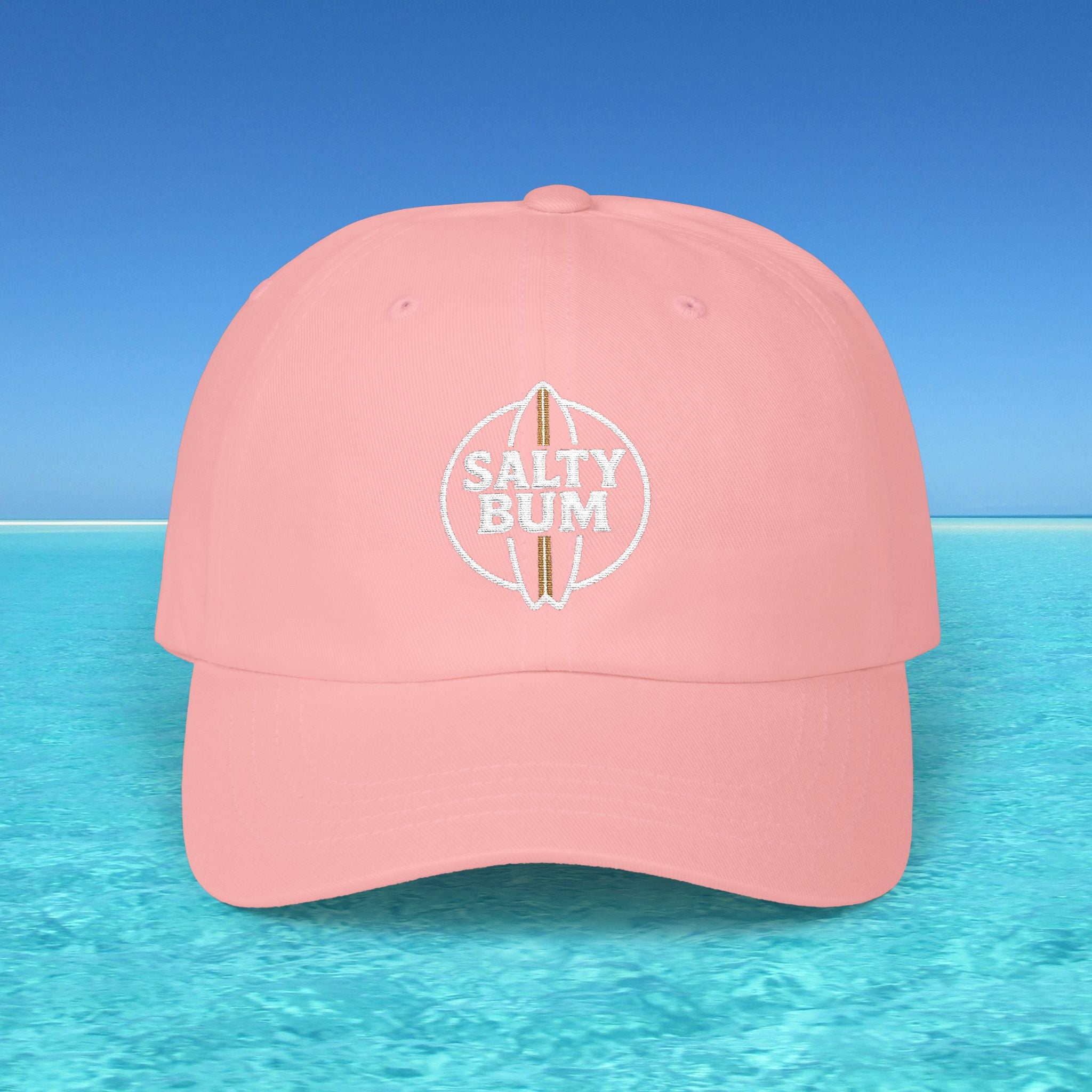 Pink cap with 'Salty Bum' logo on a blue water and sky background
