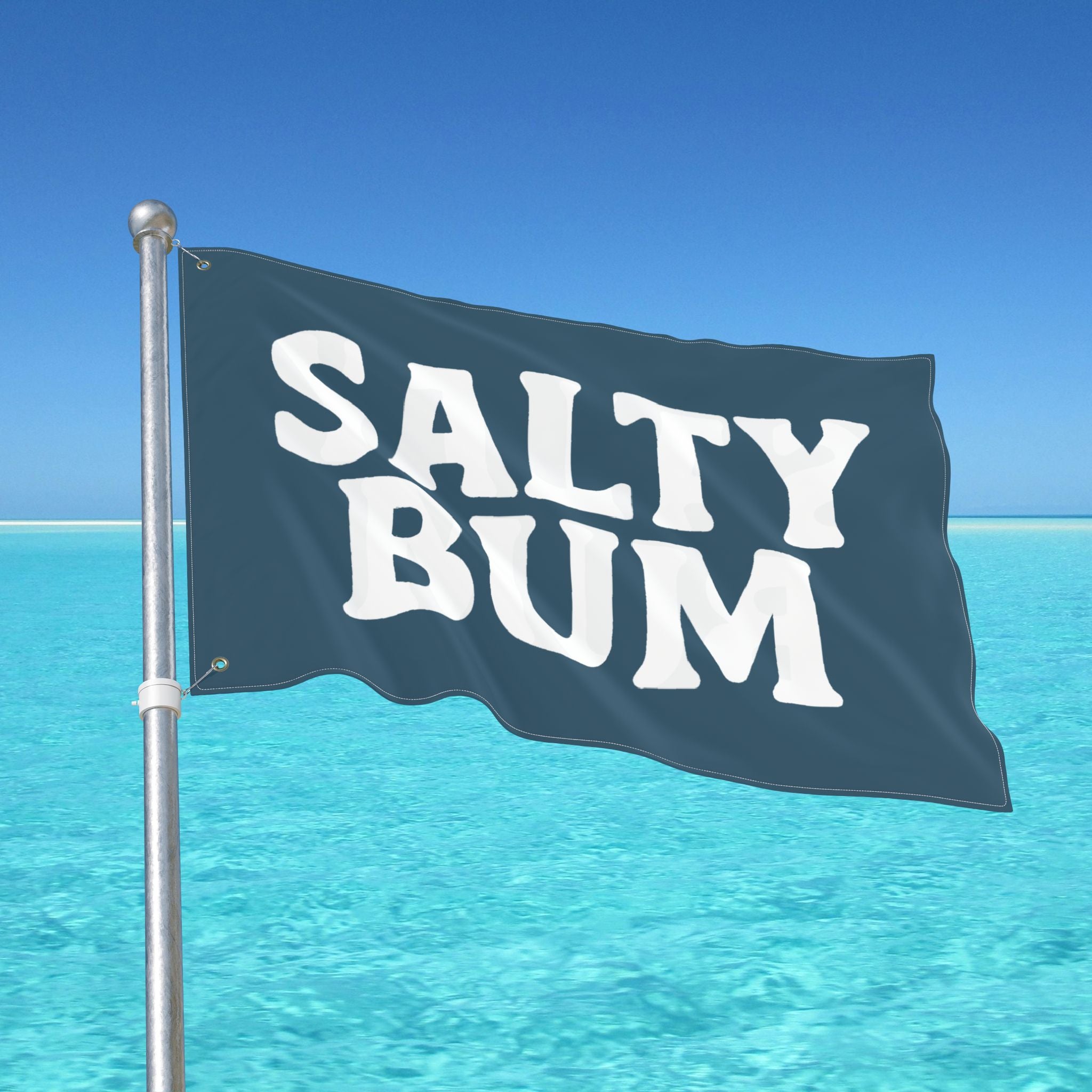 Flag with 'Salty Bum' text waving in front of a clear blue sky and ocean.