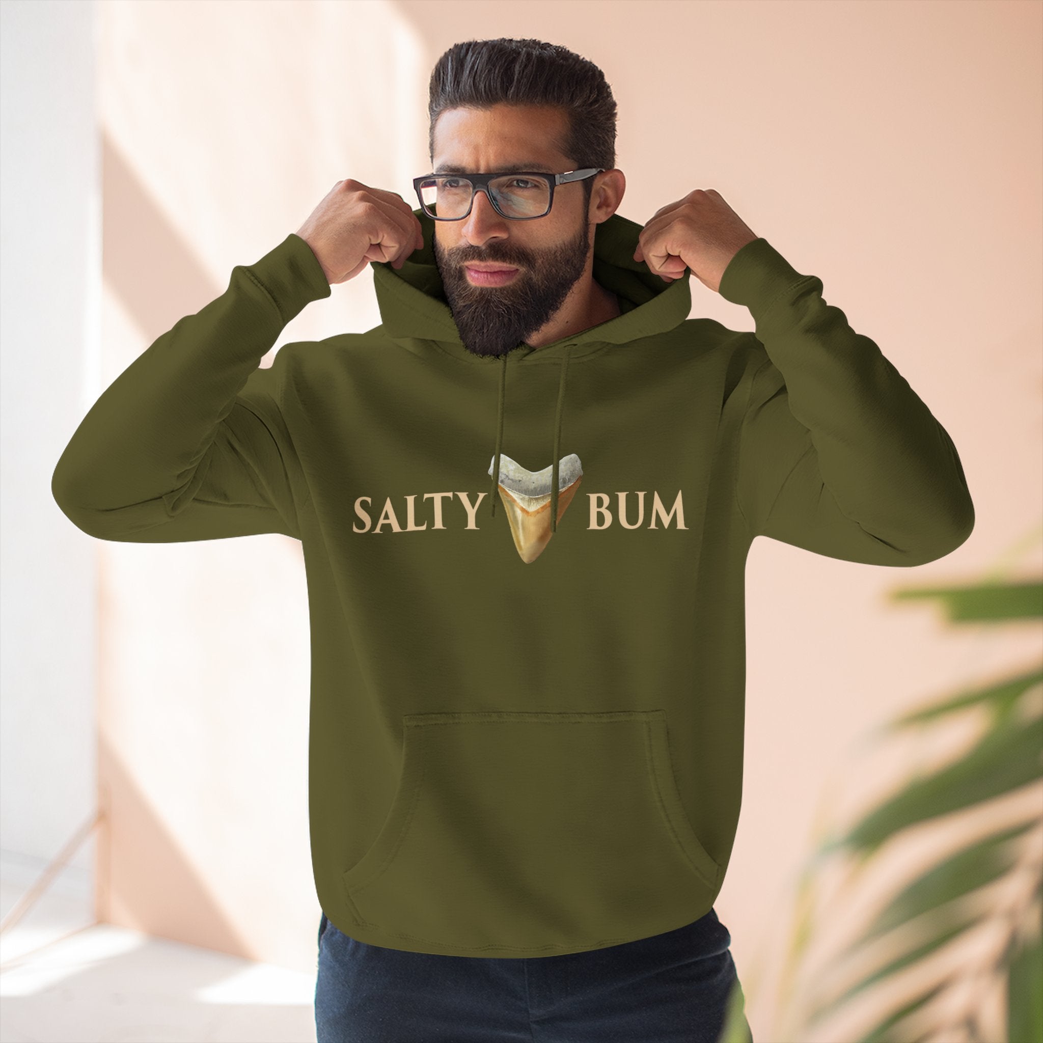 Man wearing a green hoodie with 'Salty Bum' text and graphic indoors.