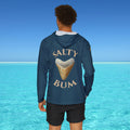 Person wearing a blue hoodie with 'Salty Bum' text and shark tooth graphic against a clear blue sky and ocean.