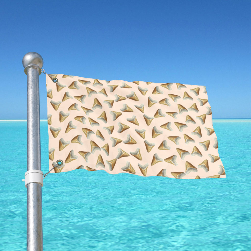 Flag with shark tooth pattern on a pole over clear blue water
