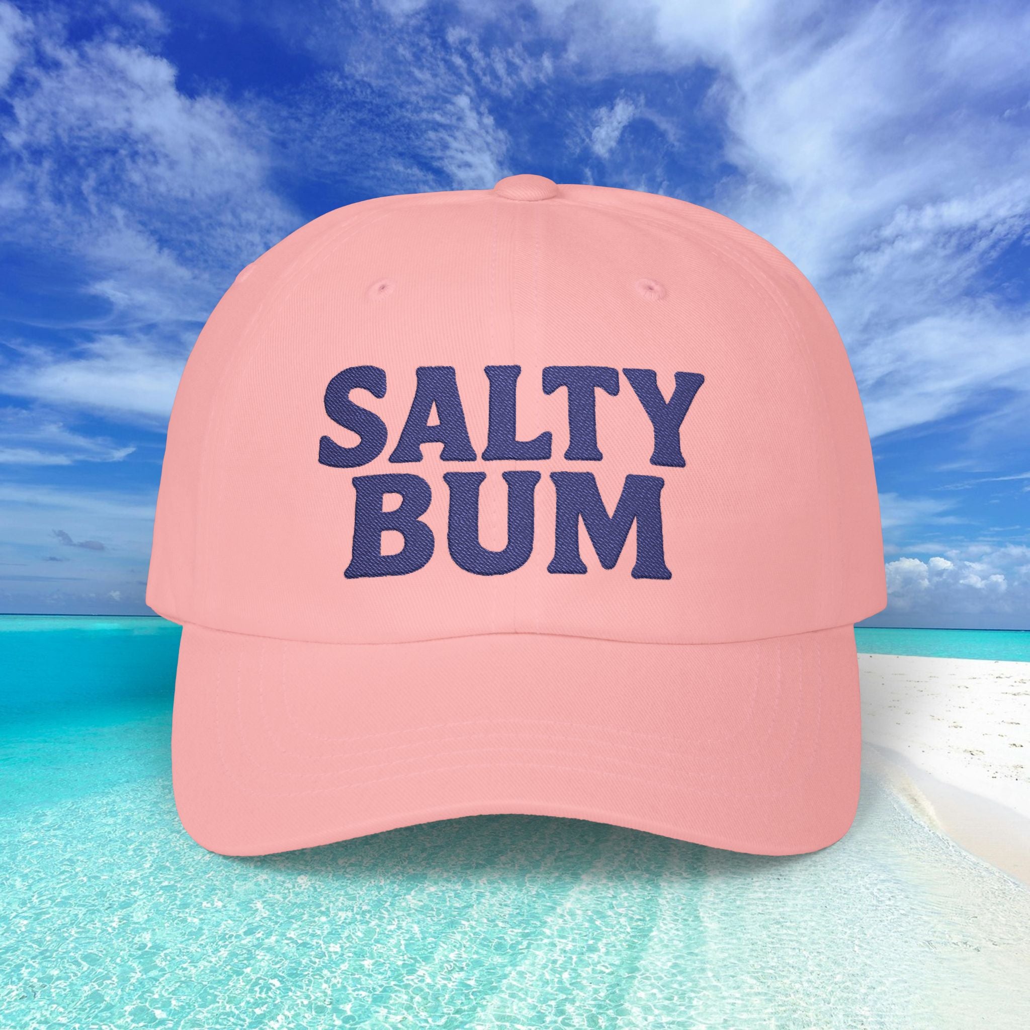 Pink cap with 'Salty Bum' text against a beach background