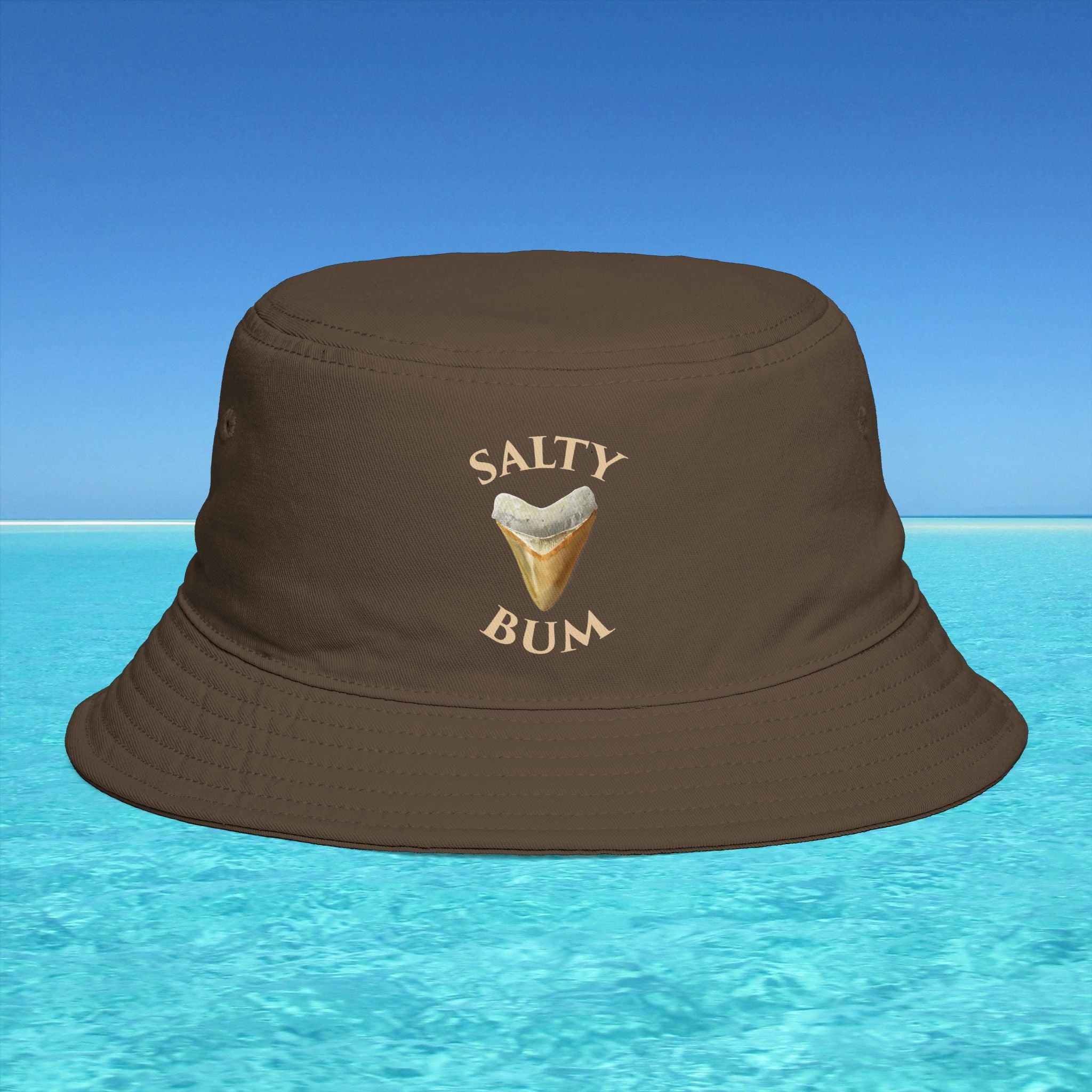 Brown bucket hat with 'Salty Bum' text and ice cream graphic on a blue water background