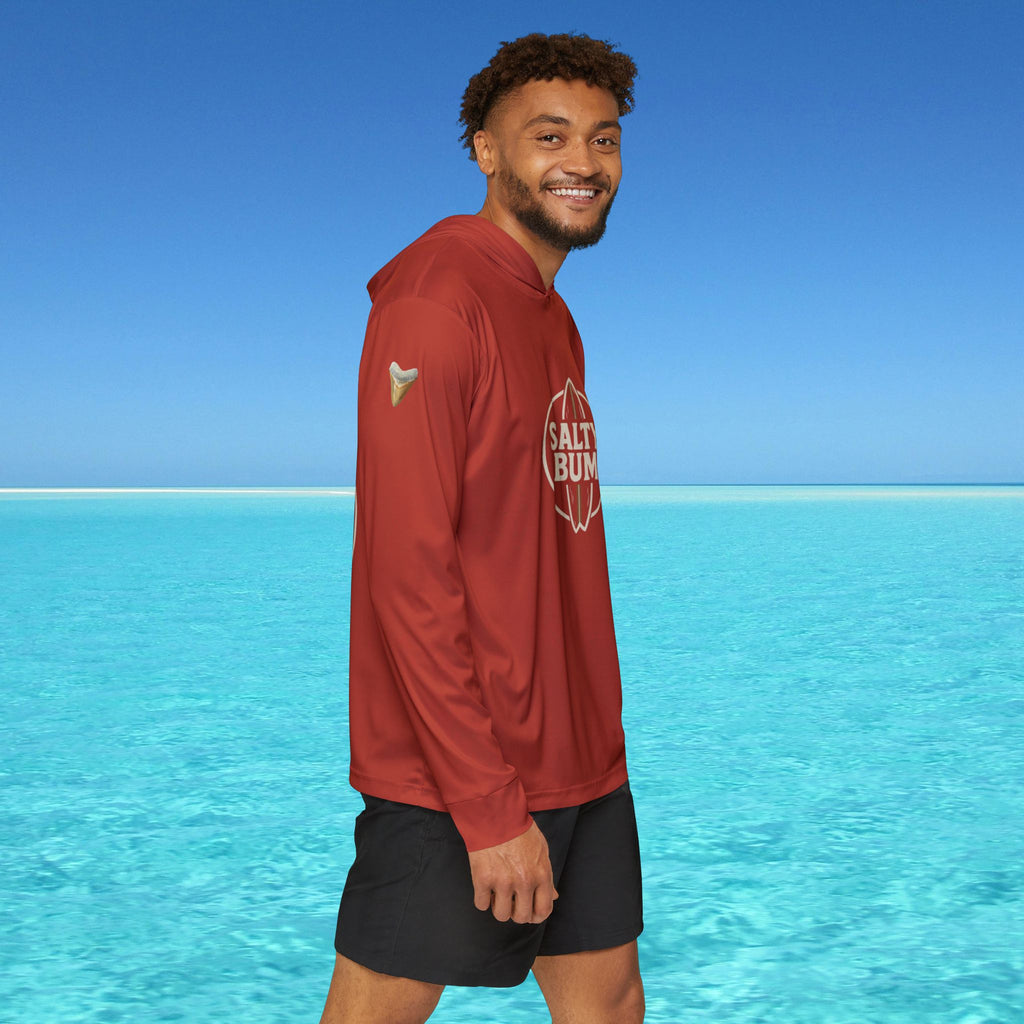 Man wearing a red hoodie with 'Salt Bae' logo standing in clear blue water.