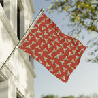 Red flag with gold and white pattern waving in front of a building