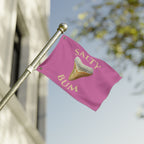 Pink flag with 'Salty Bum' text and shark tooth graphic on a pole against a blurred background
