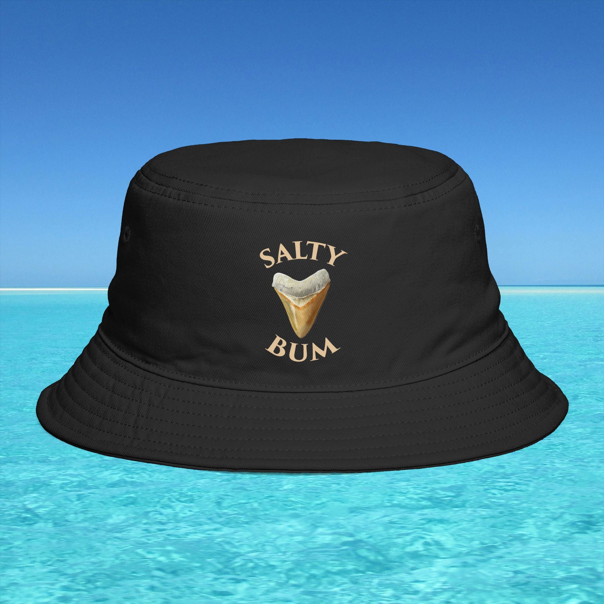 Black bucket hat with 'Salty Bum' text and ice cream graphic on a blue water background