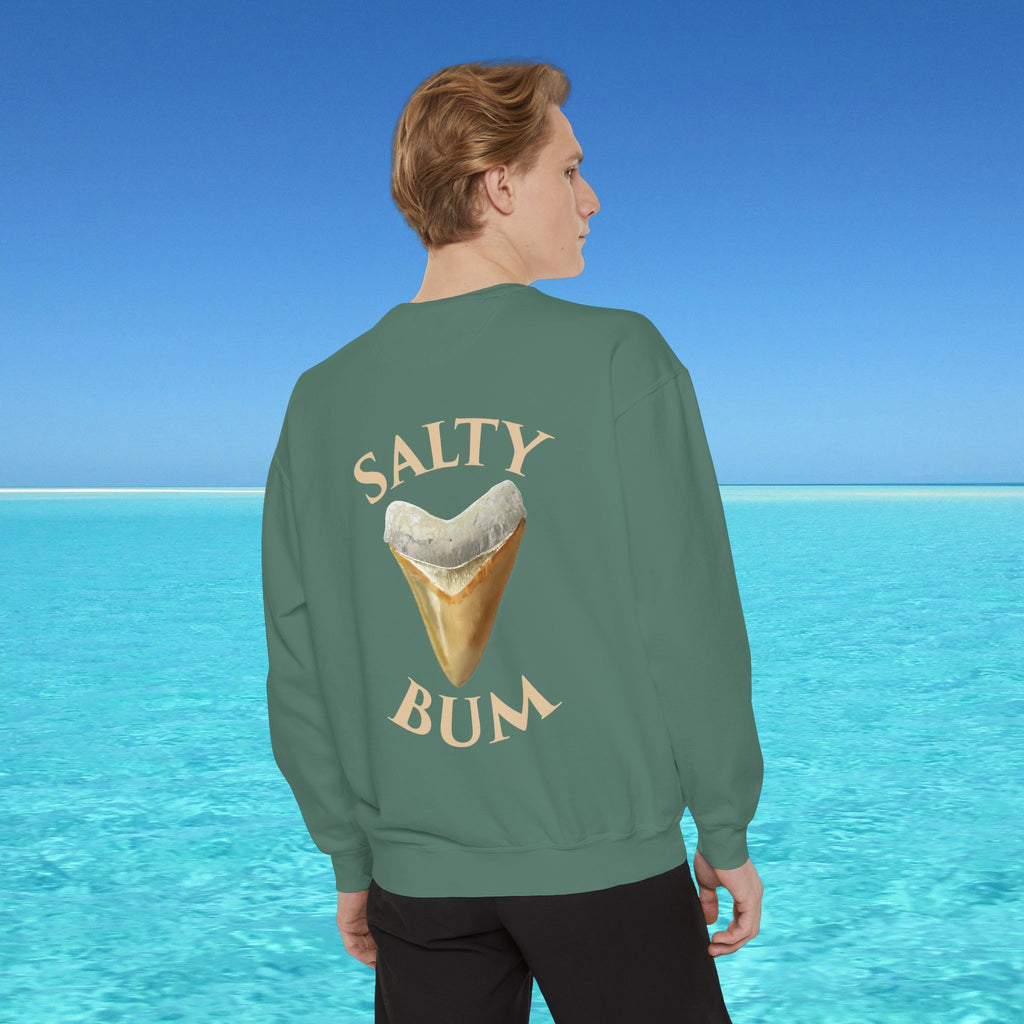 Person wearing a green sweatshirt with 'Salty Bum' text and ice cream cone graphic, standing in front of a blue ocean.