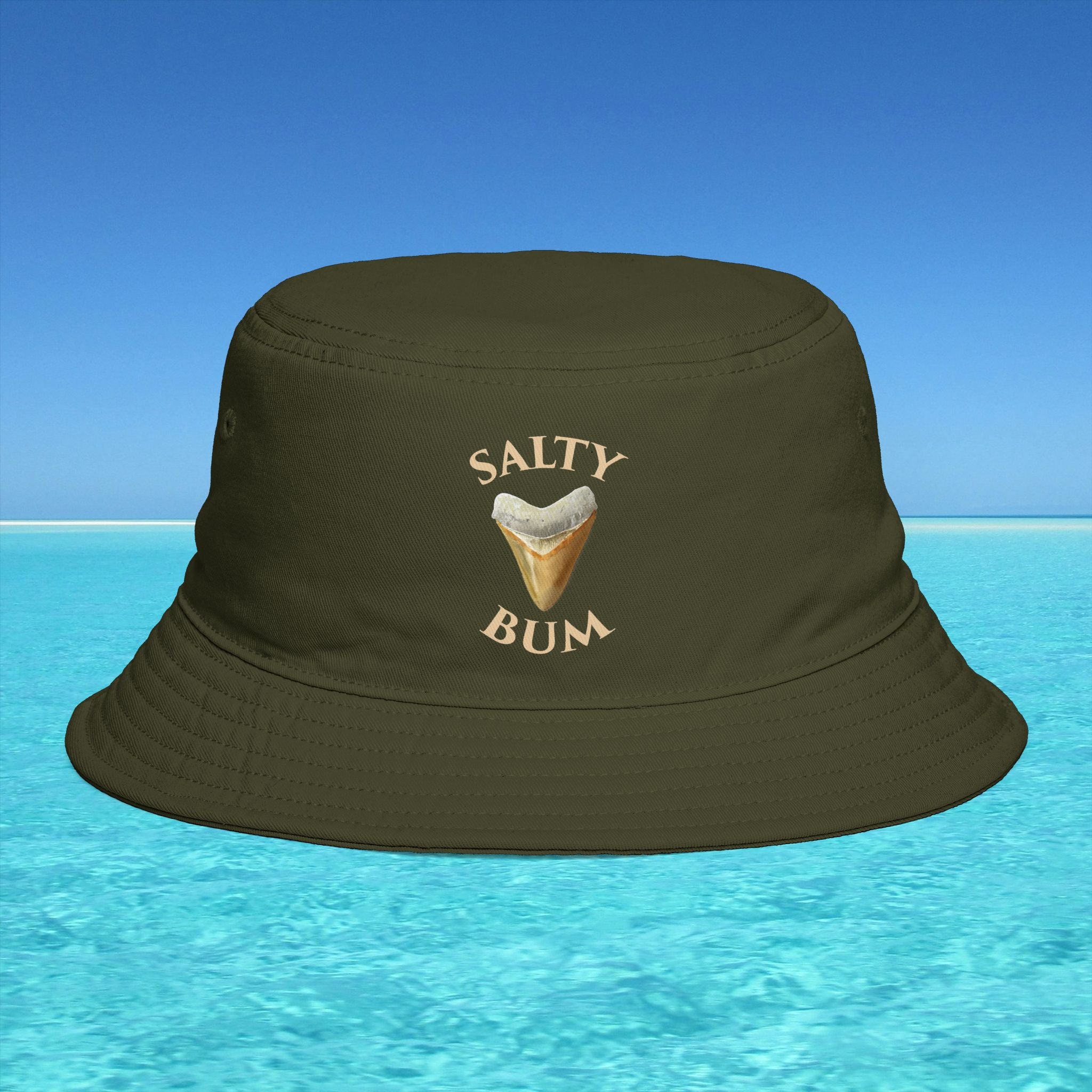 Brown bucket hat with 'Salty Bum' text and ice cream graphic on a blue water and sky background