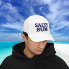 Person wearing a white cap with 'Salty Bum' text on a beach
