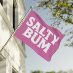 Pink flag with 'Salty Bum' text on a building facade