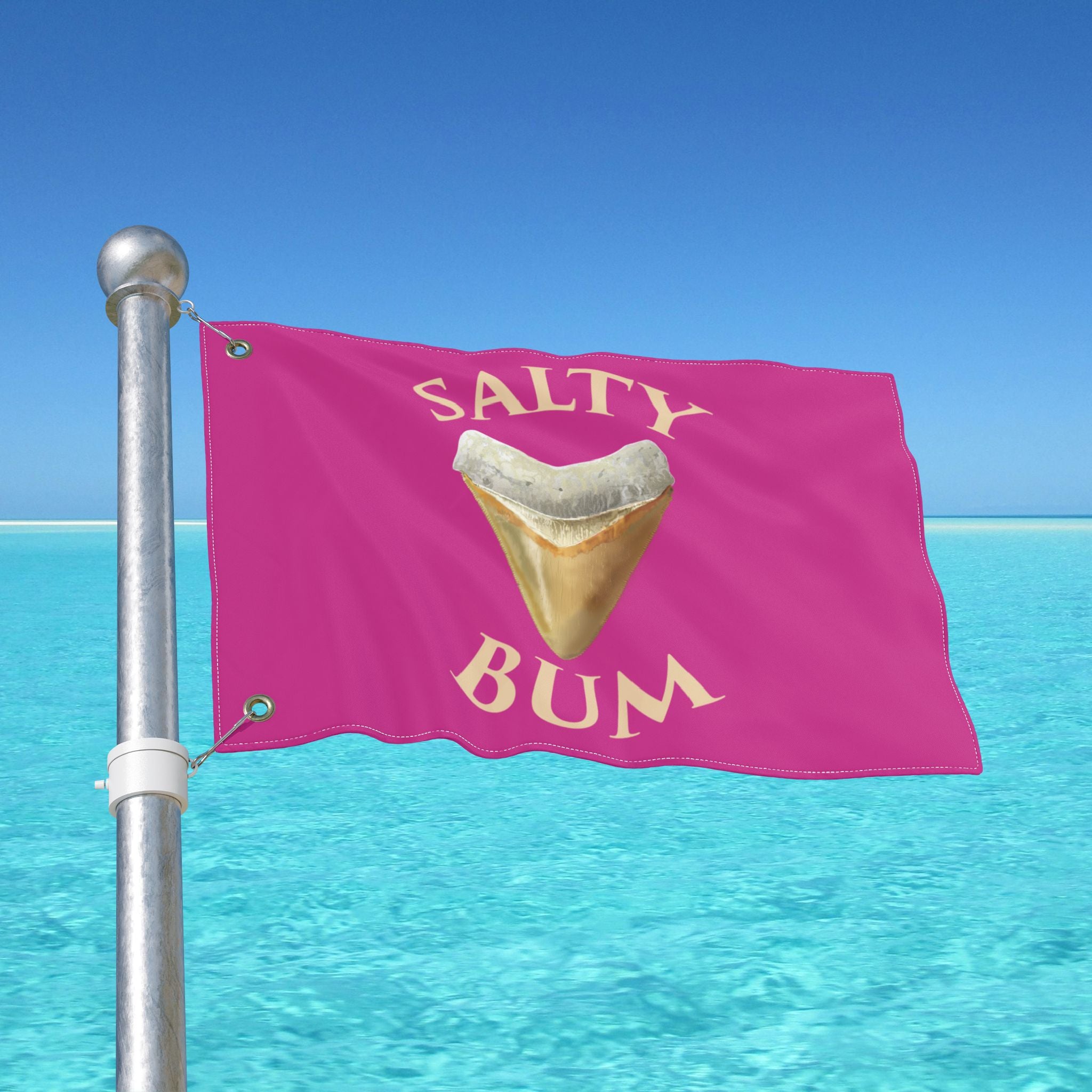 Pink flag with 'Salty Bum' text and shark tooth graphic against a clear blue sky.