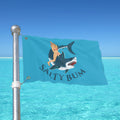 Flag with a graphic of a person on a shark and 'Salty Bum' text, against a clear blue sky.