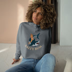 Woman wearing a gray sweatshirt with a graphic design and text, sitting indoors.