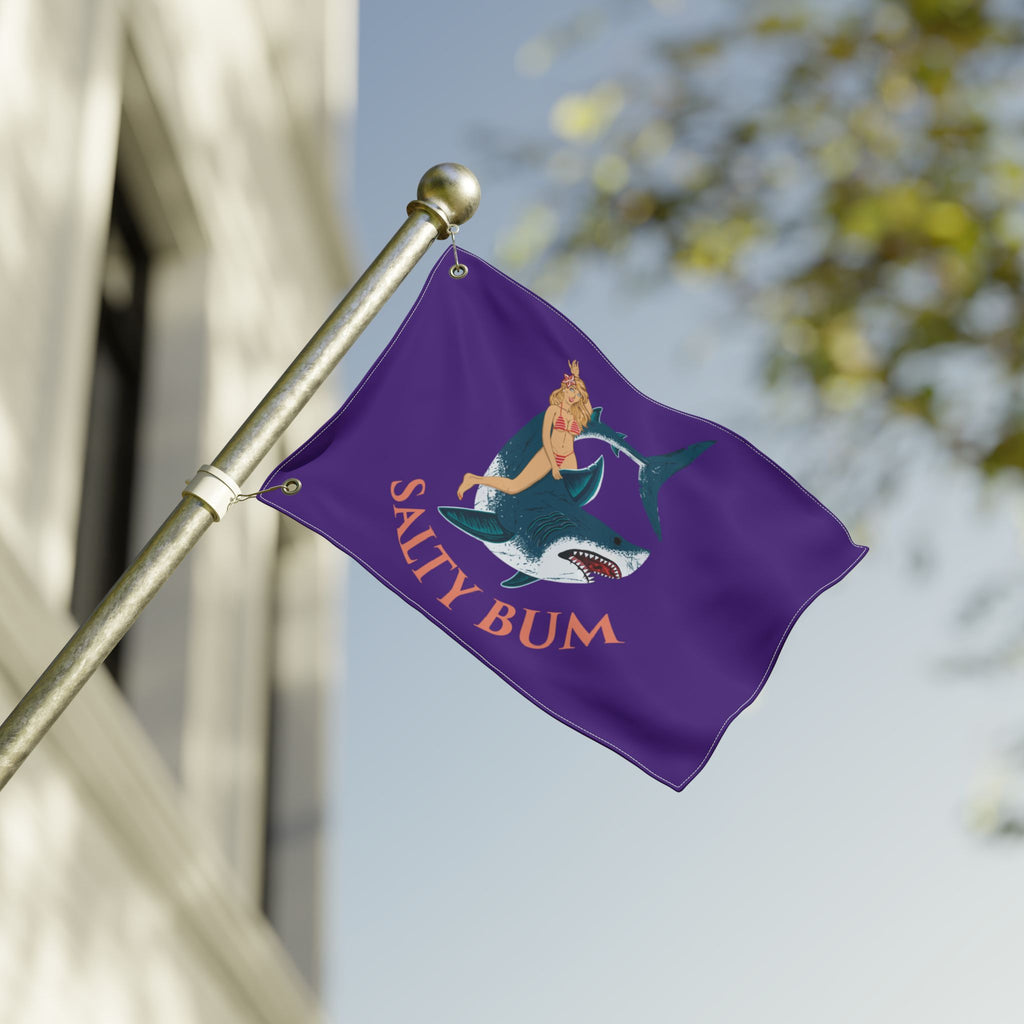 Purple flag with a mermaid and shark design and 'Salty Bum' text, waving on a flagpole.