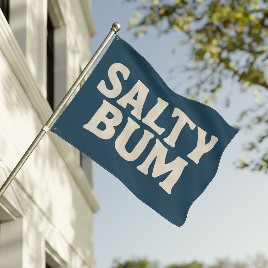 Flag with 'Salty Bum' text waving in front of a building