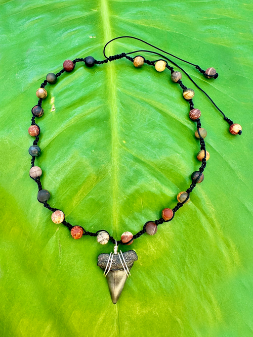 mako shark tooth necklace made with black string and earth tone beads